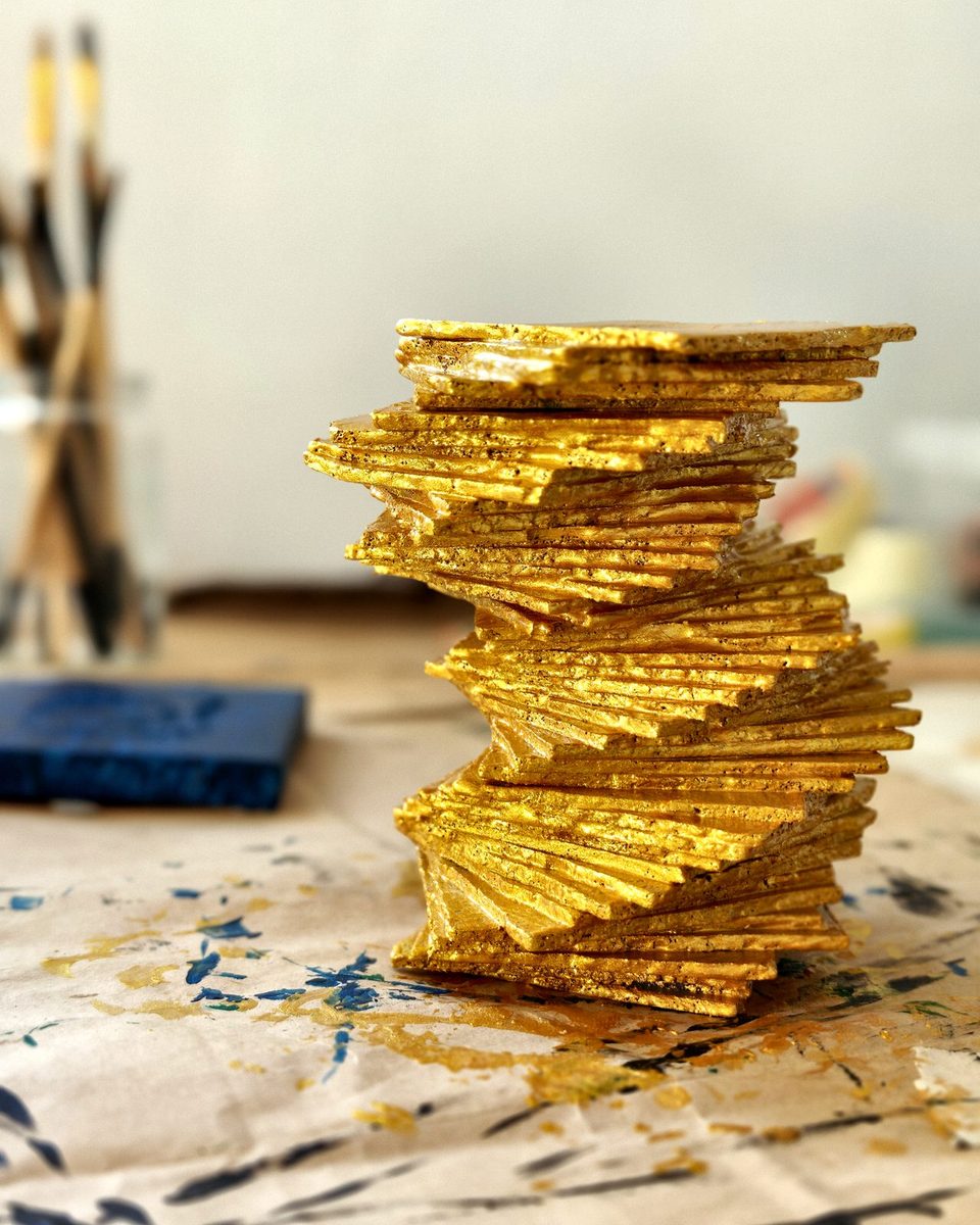 Sculptural tower of stacked gold-leaf layers